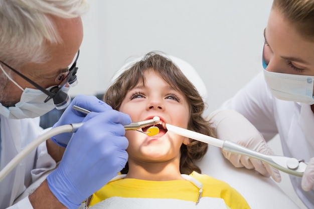 Dentiste pédiatrique et assistant examinant les dents d&#39;un petit garçon