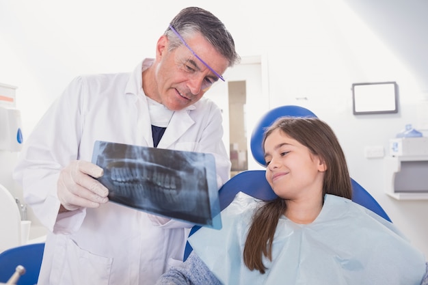 Dentiste pédiatrique expliquant à la jeune patiente la radiographie