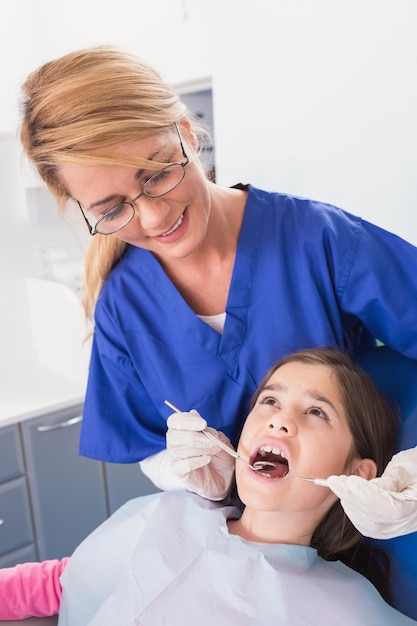 Dentiste pédiatrique faisant l&#39;examen chez un jeune patient effrayé