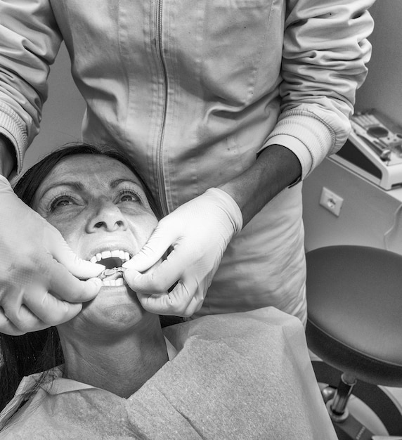 Dentiste prenant l'empreinte dentaire au patient dans le cabinet dentaire.