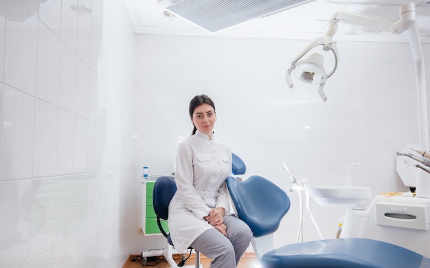 Un dentiste professionnel se tient dans un cabinet dentaire léger moderne. Dentisterie.