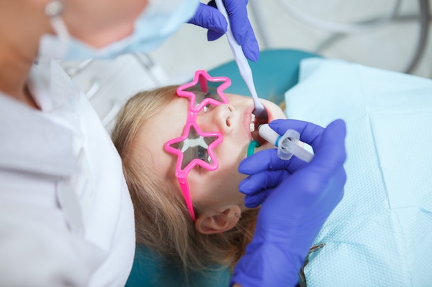 Dentiste professionnel traitant les dents du petit patient