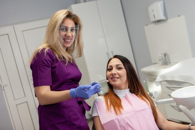 Une dentiste professionnelle examine les dents d'un patient dans une clinique dentaire.