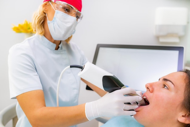 Dentiste en prothèse dentaire à l'aide d'une caméra 3D dans la procédure de reconstruction des dents