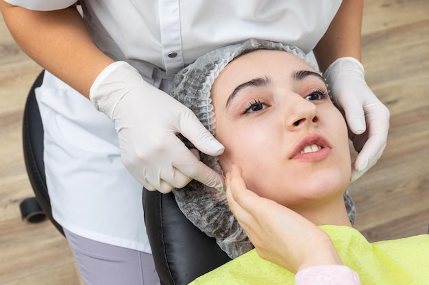 Le dentiste regarde une mâchoire d'une patiente féminine qui vérifie la morsure.