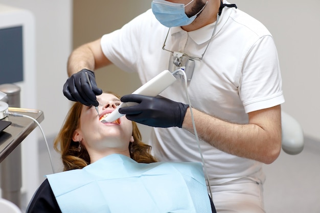 Le dentiste scanne les dents du patient avec un scanner 3D.