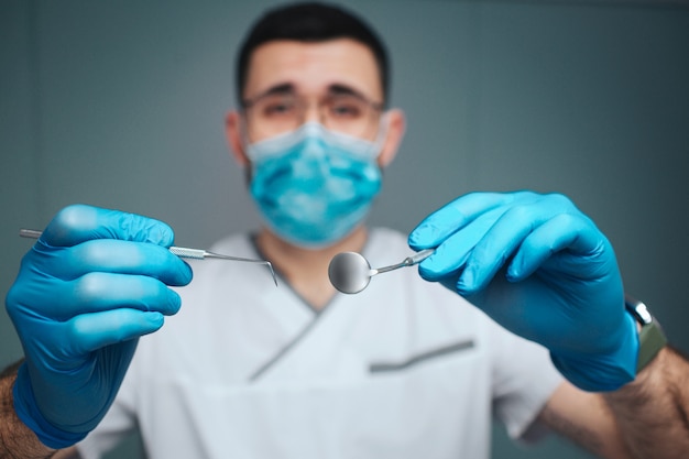 dentiste de sexe masculin en uniforme et masque