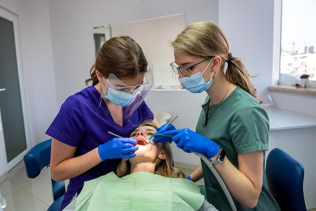 Le dentiste et son assistant examinent la cavité buccale et traitent le client