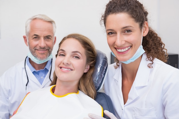 Dentiste son assistant et patient tout sourire à la caméra