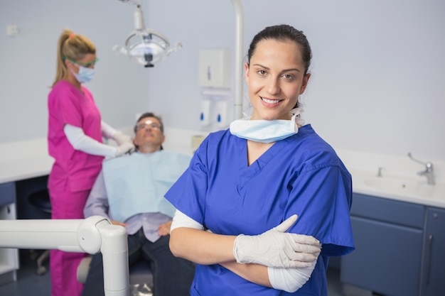 Dentiste souriant avec les bras croisés