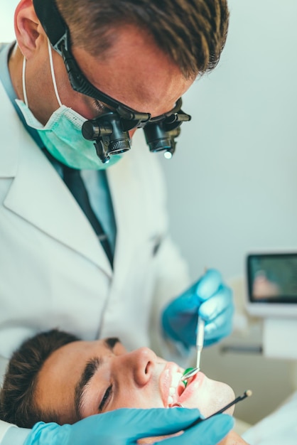 Dentiste travaillant avec un jeune homme