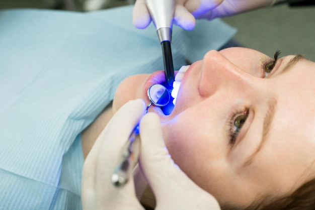 Dentiste Travaillant Avec Une Lampe à Polymérisation Dentaire