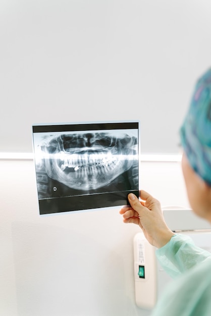 Une dentiste vérifie une radiographie de la bouche d'un patient