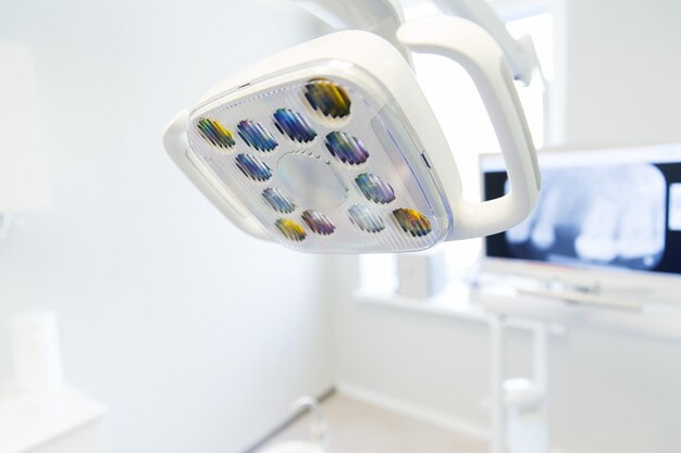 dentisterie, médecine, équipement médical et concept de stomatologie - gros plan d'une lampe au bureau de la clinique dentaire
