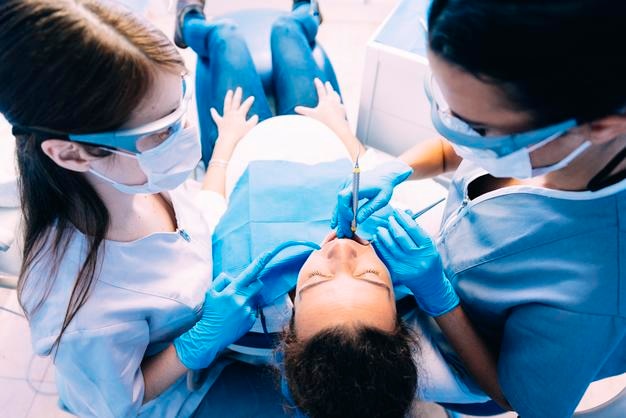 Des dentistes examinent une femme enceinte dans une clinique