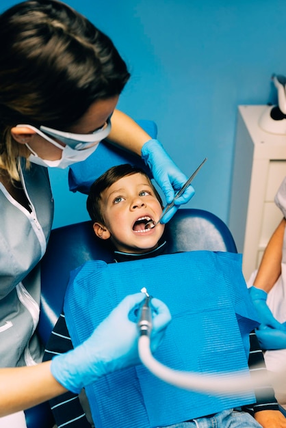 Des dentistes examinent un garçon à la clinique.