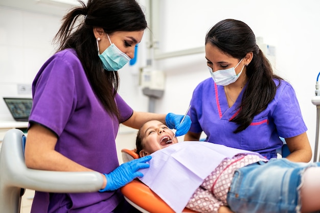 Dentistes Lors D'une Intervention Dentaire Avec Un Patient. Concept De Dentiste