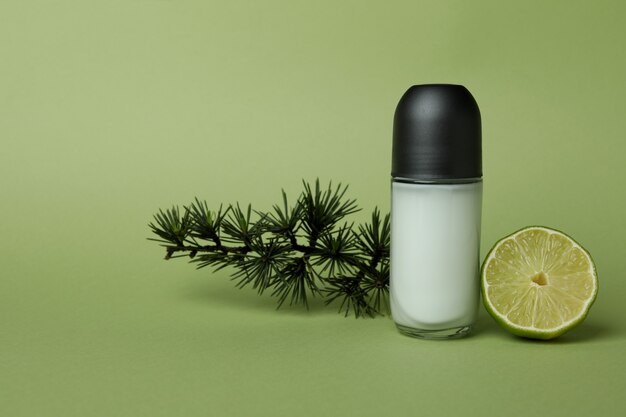 Photo déodorant vierge, brindille d'épinette et citron vert sur fond vert