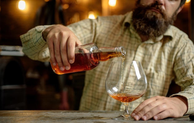 Dépendance à l'alcool Homme barbu buvant de l'alcool Whisky brandy ou cognac concept Grave homme triste havin