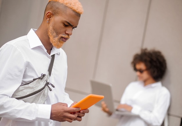 Dépendance à Internet. Deux personnes avec des appareils électroniques dans la rue