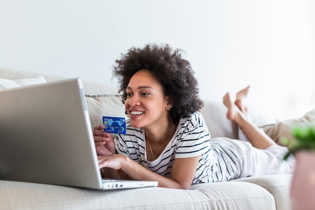 Photo les dépenses de consommation féminine achetant sur internet, mode de vie. femme heureuse, faire du shopping en ligne avec un ordinateur portable à la maison.