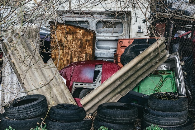 Photo un dépotoir de voitures rouillées cassées leurs pièces et pneus