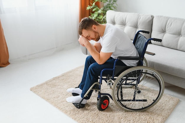 Dépression et solitude chez un homme handicapé Homme âgé en fauteuil roulant pleurant à l'intérieur