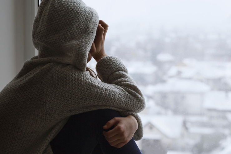 Photo déprimé bouleversé triste adolescente regarde par la fenêtre vers l'appareil photo difficile maturation adolescente