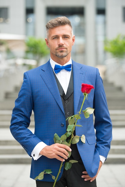 Dernier célibataire sur Terre Saint Valentin et anniversaire Services de rencontres Comment être romantique Gentleman romantique Homme mature macho confiant avec un cadeau romantique Beau mec rose fleur rendez-vous romantique