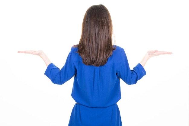 Derrière la vue arrière jeune femme brune en robe bleue lui montrant deux paumes vides