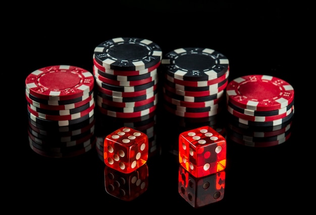 Dés avec une combinaison gagnante maximale de douze au poker sur une table noire et des jetons en arrière-plan