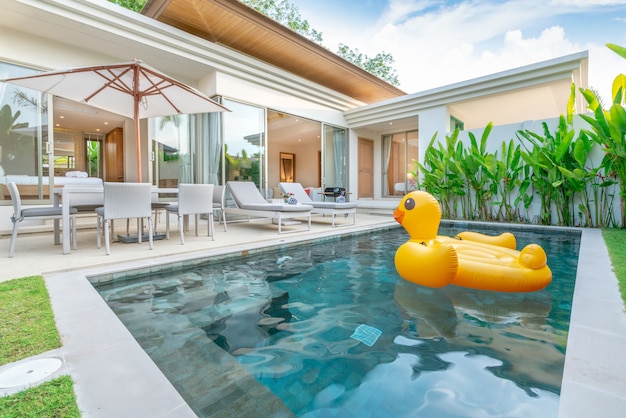 Design extérieur montrant une villa avec piscine tropicale et jardin de verdure