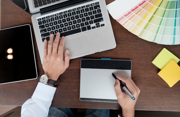 Design graphique et échantillons de couleurs et stylos sur un bureau.