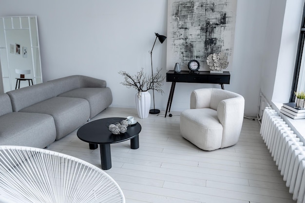 Design d'intérieur minimaliste moderne d'une chambre monochrome lumineuse et lumineuse avec des meubles en noir et blanc, des murs blancs et d'immenses fenêtres