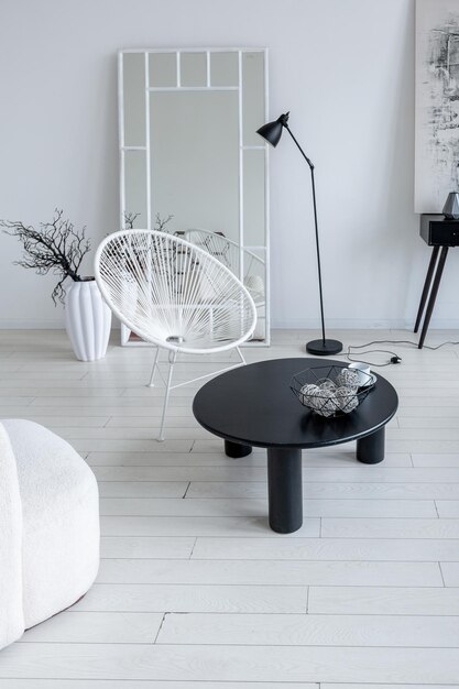 Design d'intérieur minimaliste moderne d'une chambre monochrome lumineuse et lumineuse avec des meubles en noir et blanc, des murs blancs et d'immenses fenêtres