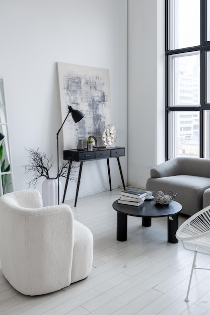 Design d'intérieur minimaliste moderne d'une chambre monochrome lumineuse et lumineuse avec des meubles en noir et blanc, des murs blancs et d'immenses fenêtres