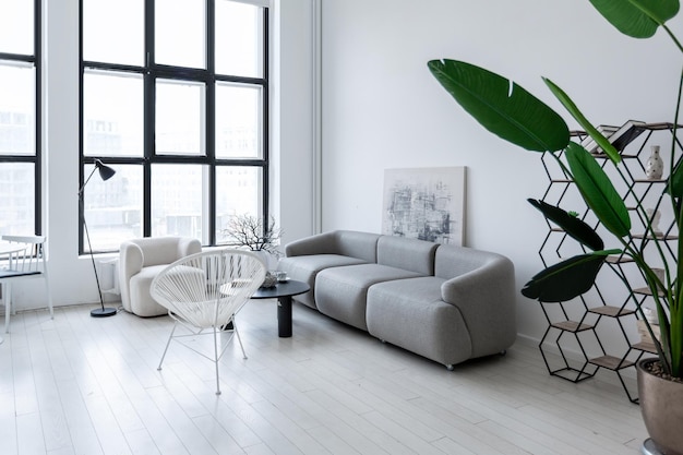 Design d'intérieur minimaliste moderne d'une chambre monochrome lumineuse et lumineuse avec des meubles en noir et blanc, des murs blancs et d'immenses fenêtres