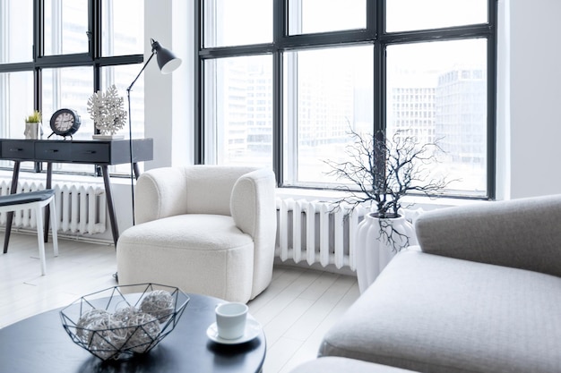 Design d'intérieur minimaliste moderne d'une chambre monochrome lumineuse et lumineuse avec des meubles en noir et blanc, des murs blancs et d'immenses fenêtres