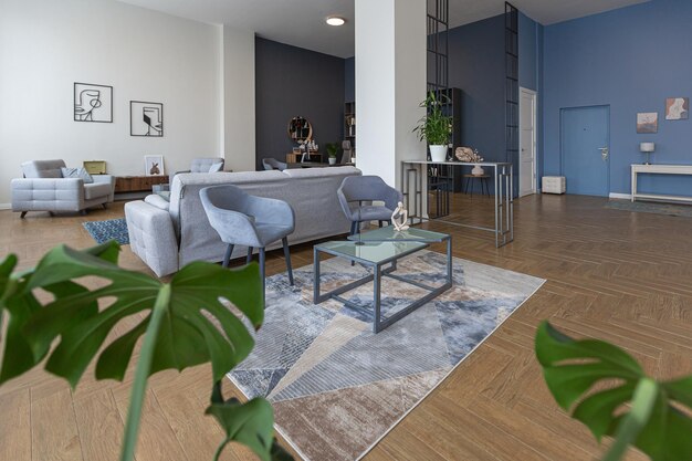 Design d'intérieur moderne minimaliste immense appartement lumineux avec un plan ouvert de style scandinave dans des couleurs bleu blanc et bleu foncé avec des colonnes au centre comprend un coin cuisine bureau et salon
