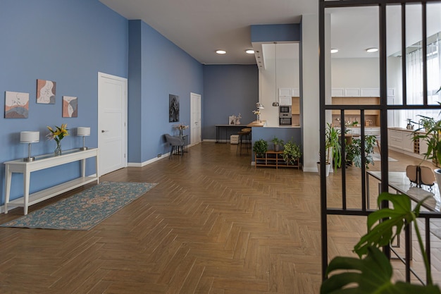 Design d'intérieur moderne minimaliste immense appartement lumineux avec un plan ouvert de style scandinave dans des couleurs bleu blanc et bleu foncé avec des colonnes au centre comprend un coin cuisine bureau et salon