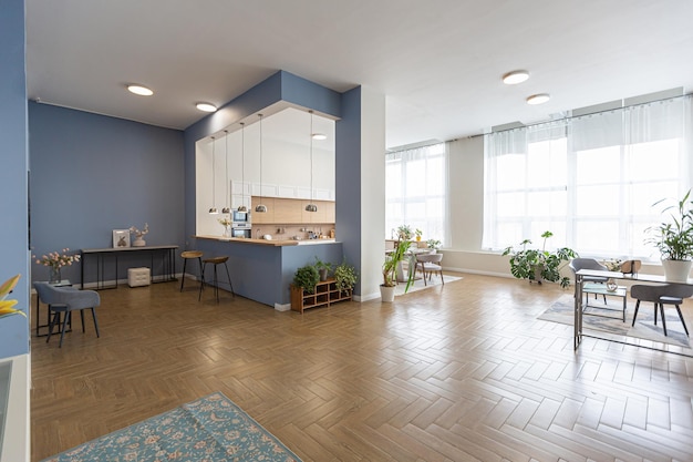 Design d'intérieur moderne minimaliste immense appartement lumineux avec un plan ouvert de style scandinave dans des couleurs bleu blanc et bleu foncé avec des colonnes au centre comprend un coin cuisine bureau et salon