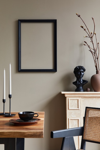 Design d'intérieur rustique de salle à manger avec table familiale en bois, chandelier, chaise rétro, tasse de café, décoration, cadre photo et accessoires personnels élégants. Mur beige.