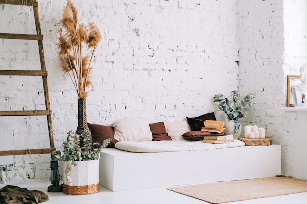 Photo design d'intérieur d'un salon lumineux avec des murs blancs et un banc de canapé avec des oreillers