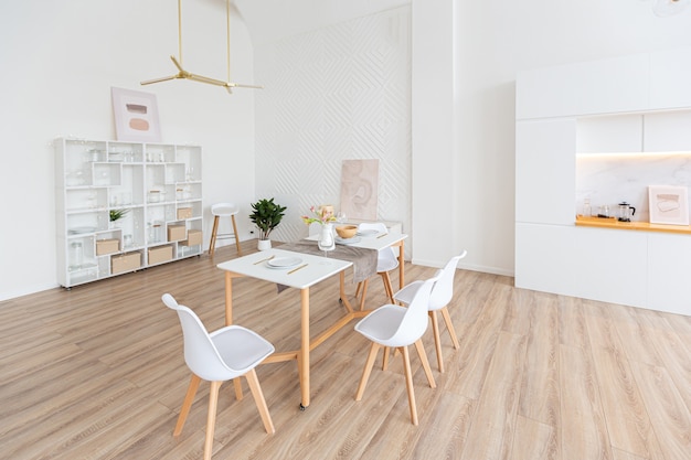 Design D'intérieur Spacieux Appartement Lumineux Dans Un Style Scandinave Et Des Tons Blancs Et Beiges Pastel Chaleureux. Mobilier Tendance Dans Le Salon Et Détails Modernes Dans Le Coin Cuisine.