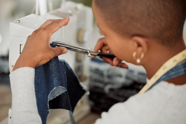 Design de mode et travail créatif dans un atelier Un ouvrier d'usine cousant des vêtements à la mode et nouveaux pour la saison avec une machine Femme coupant un fil travaillant dans un tailleur occupé