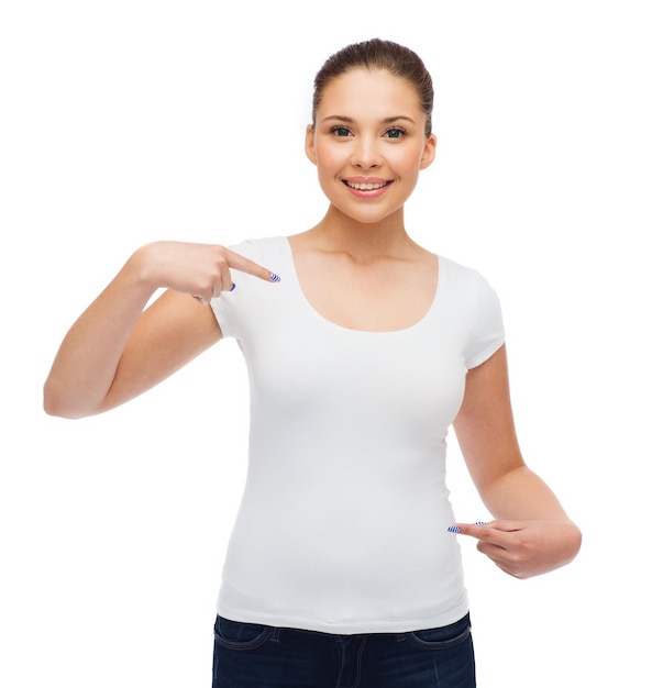 design de t-shirt, concept de personnes et de gestes - jeune femme souriante en t-shirt blanc vierge pointant les doigts sur elle-même