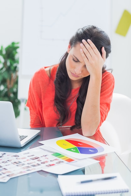 Designer agacé assis derrière son bureau