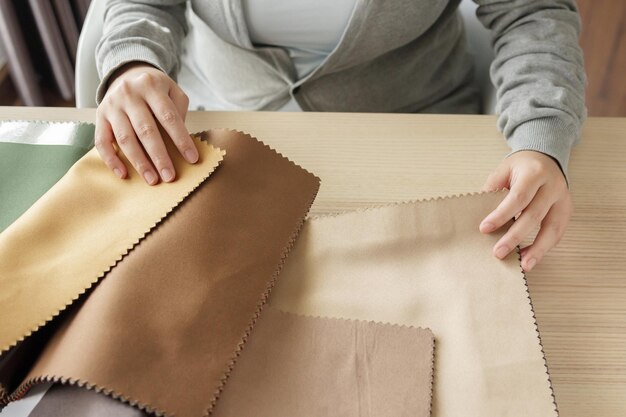 Designer féminin avec des échantillons de couleurs de tissu choisissant le textile pour les rideaux