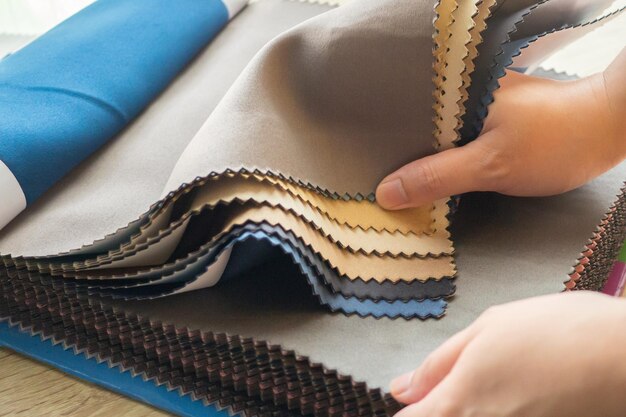 Designer féminin avec des échantillons de couleurs de tissu choisissant le textile pour les rideaux