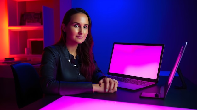 Designer fille assise à la table devant l'image générée par le réseau neuronal de l'ordinateur portable